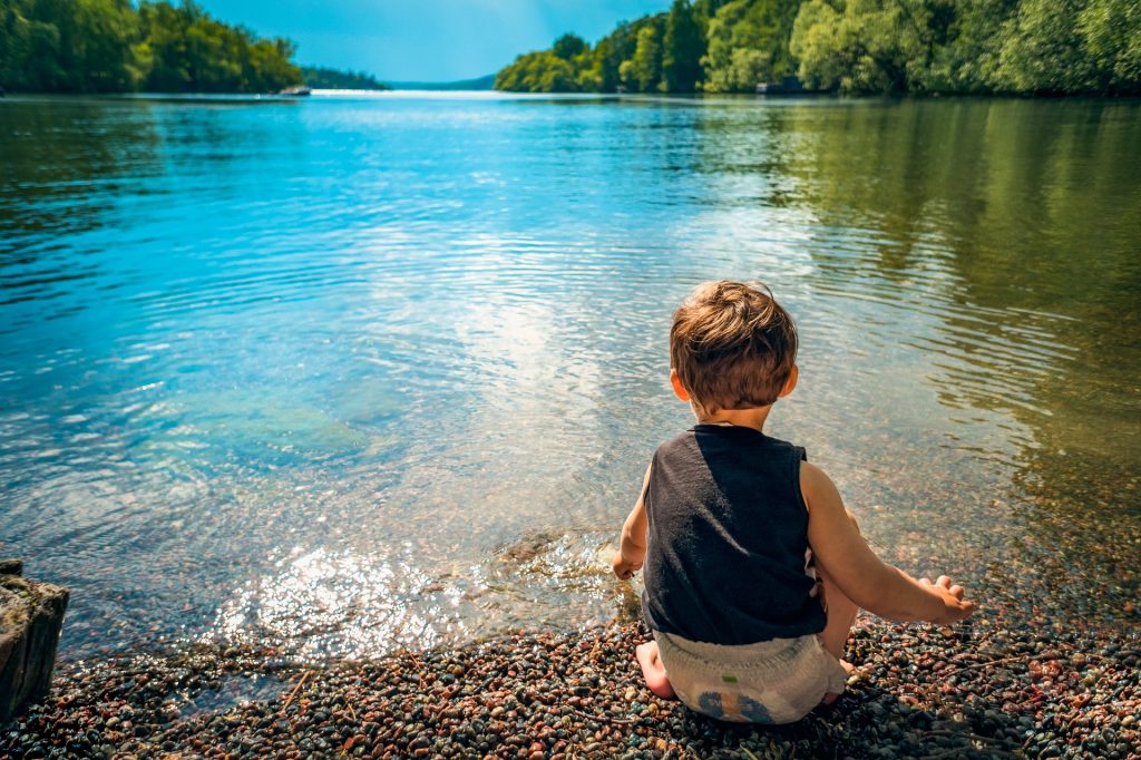 un petit garçon au bord d'un lac