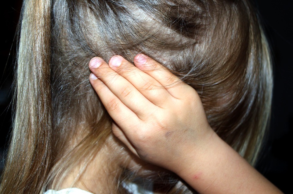 Petite fille qui se bouche les oreilles à cause du bruit