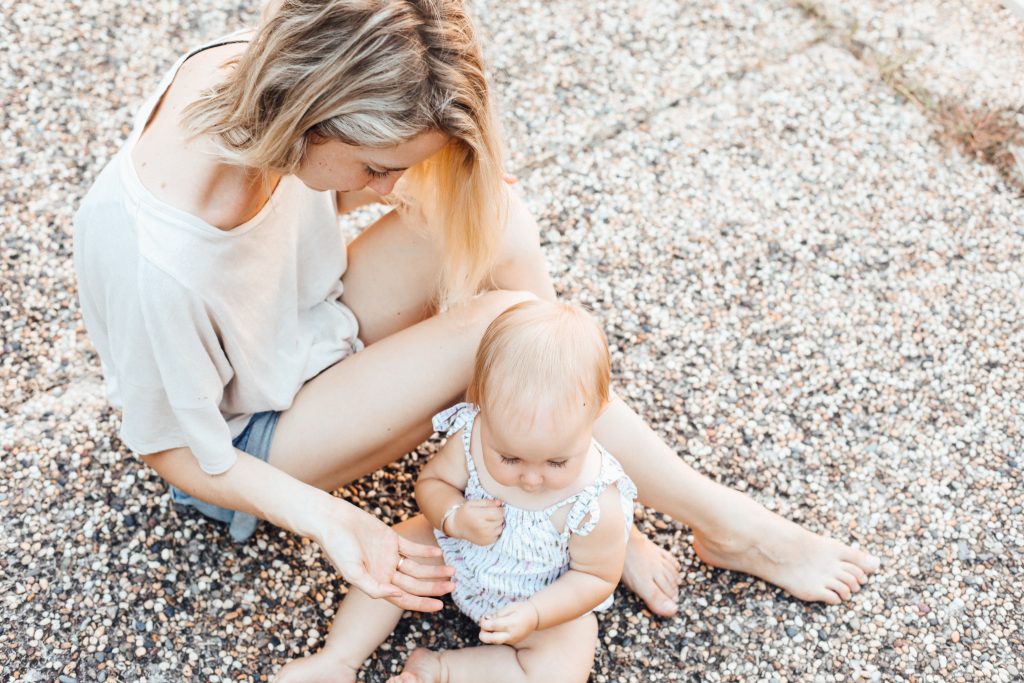 Une femme et un bébé sur le sol d'un parc