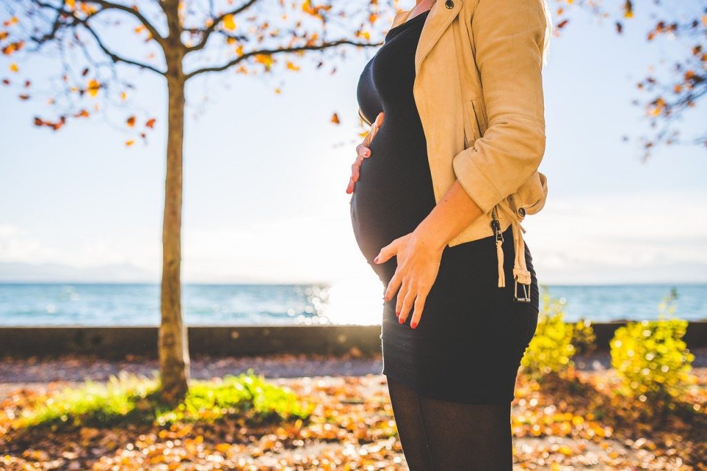 femme enceinte portant une robe noire et un blouson jaune