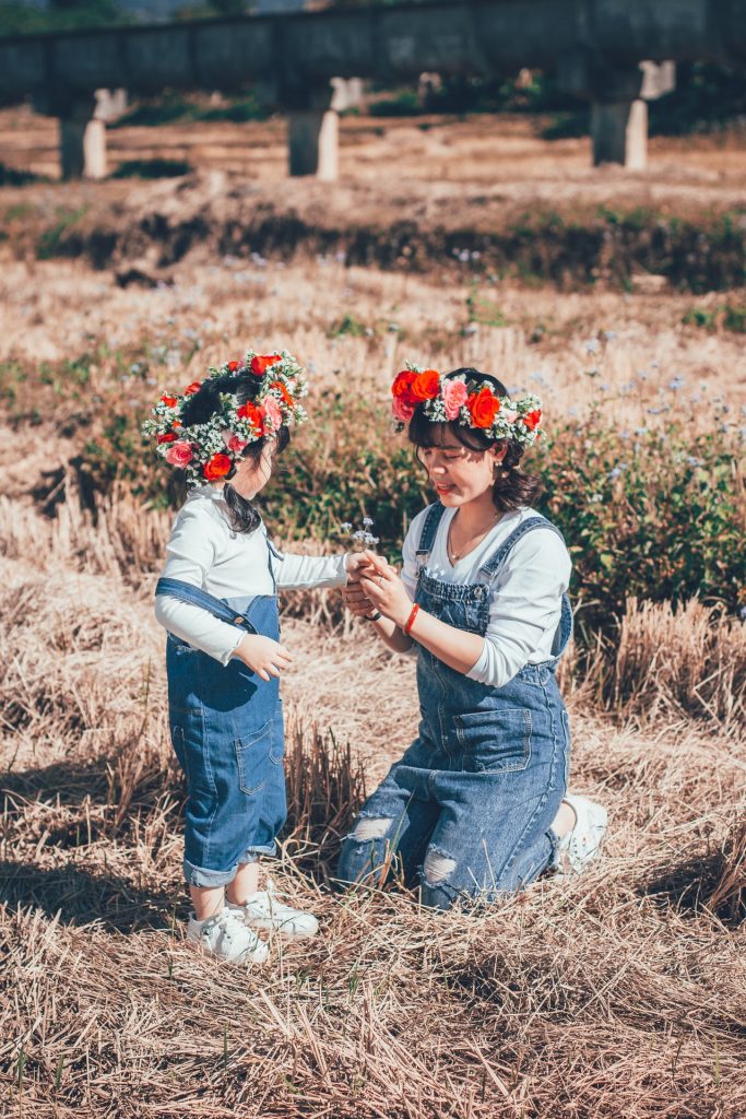 maman et fille habillée de façon similaire avec une salopette en jean et couronne de fleurs