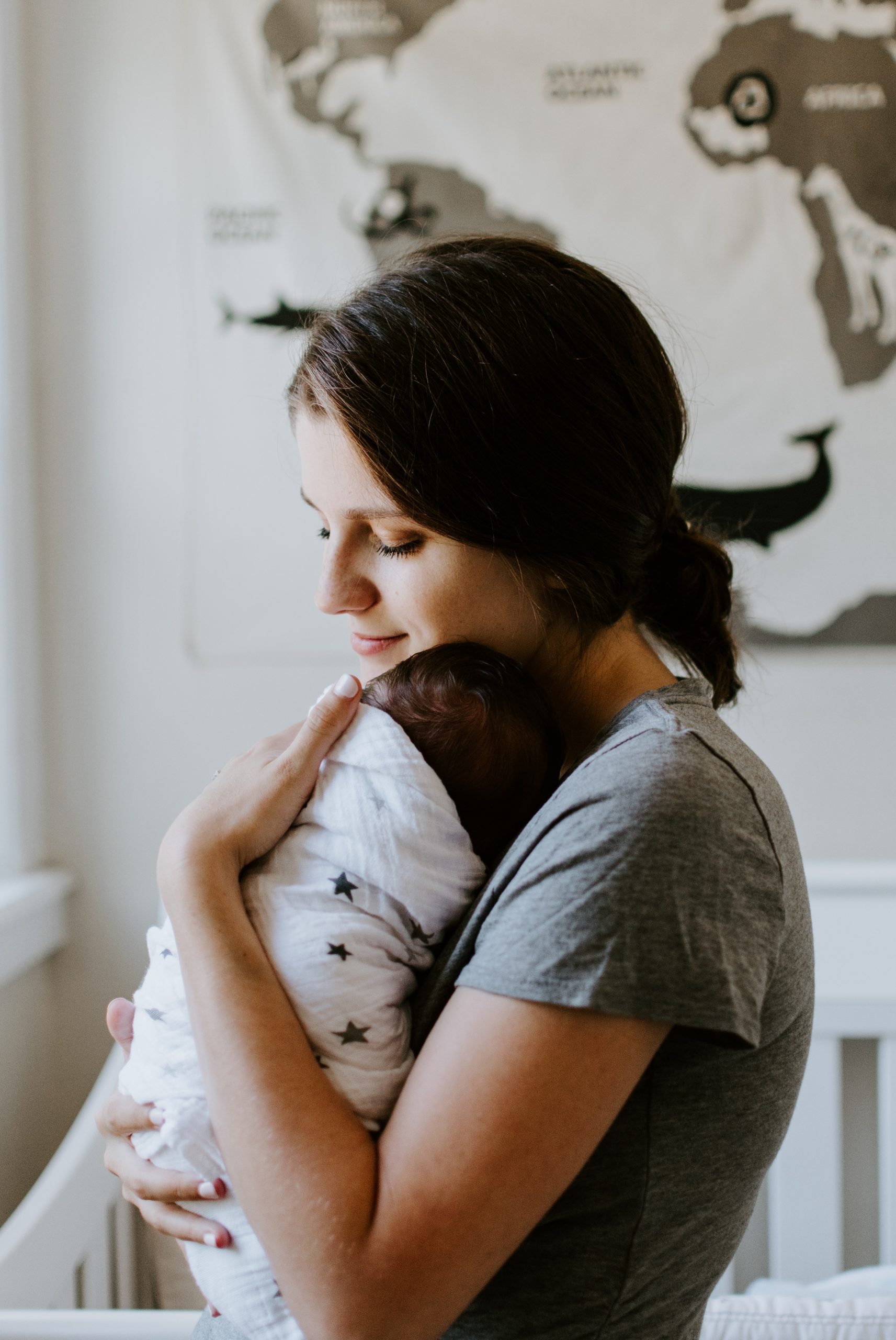 maman avec son bébé dans les bras dans un lange