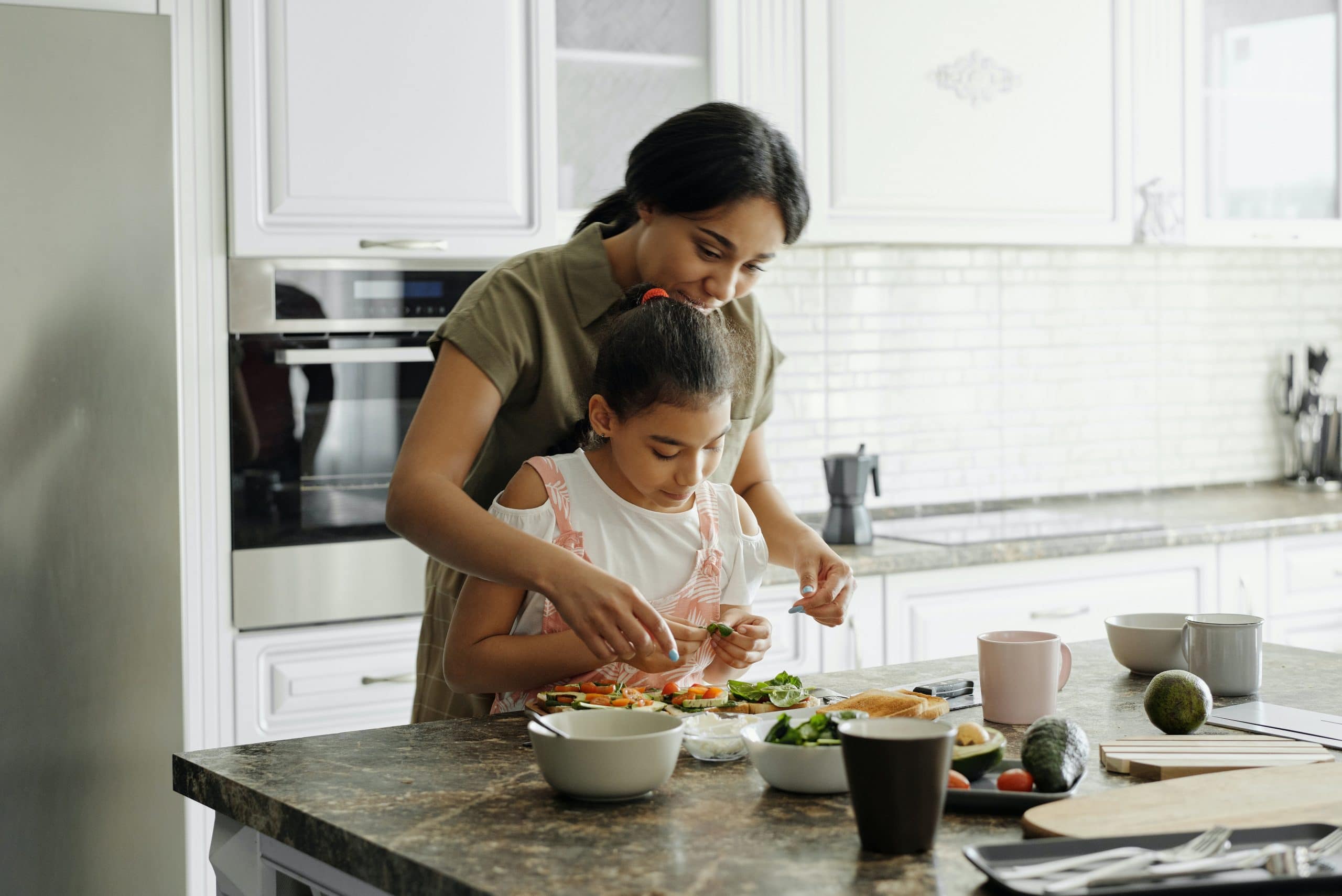 Maman qui cuisine du poisson avec son enfant